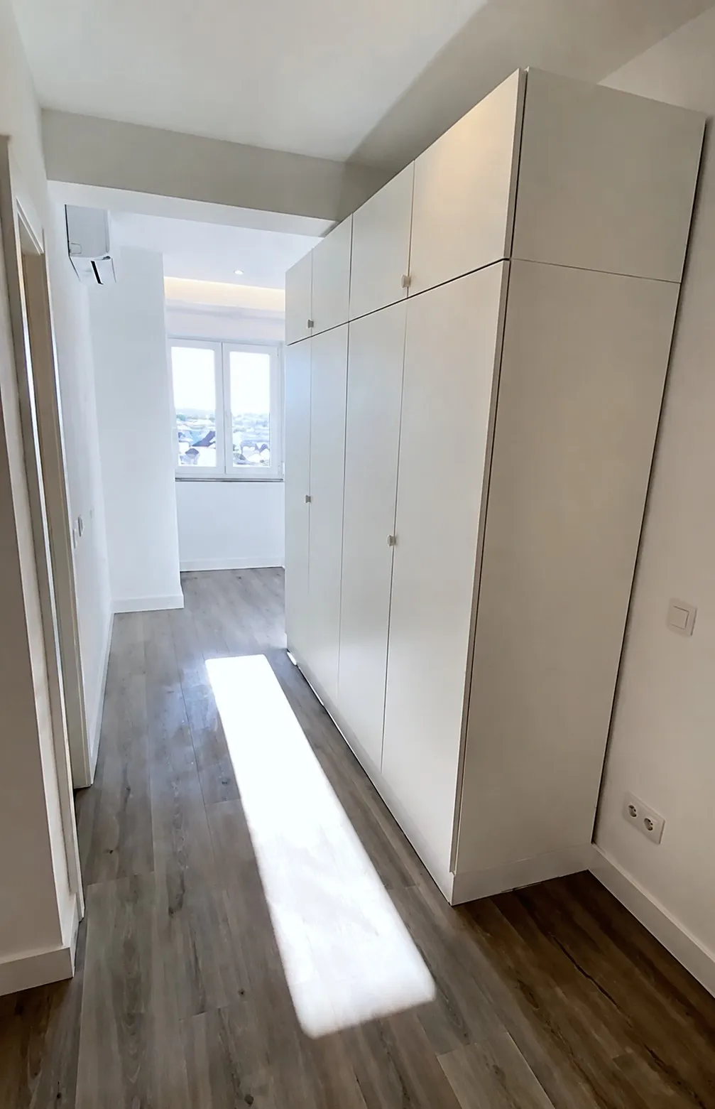 Armários de corredor em lacado branco de piso a teto, produzidos e montados pela SUDSTUDIO