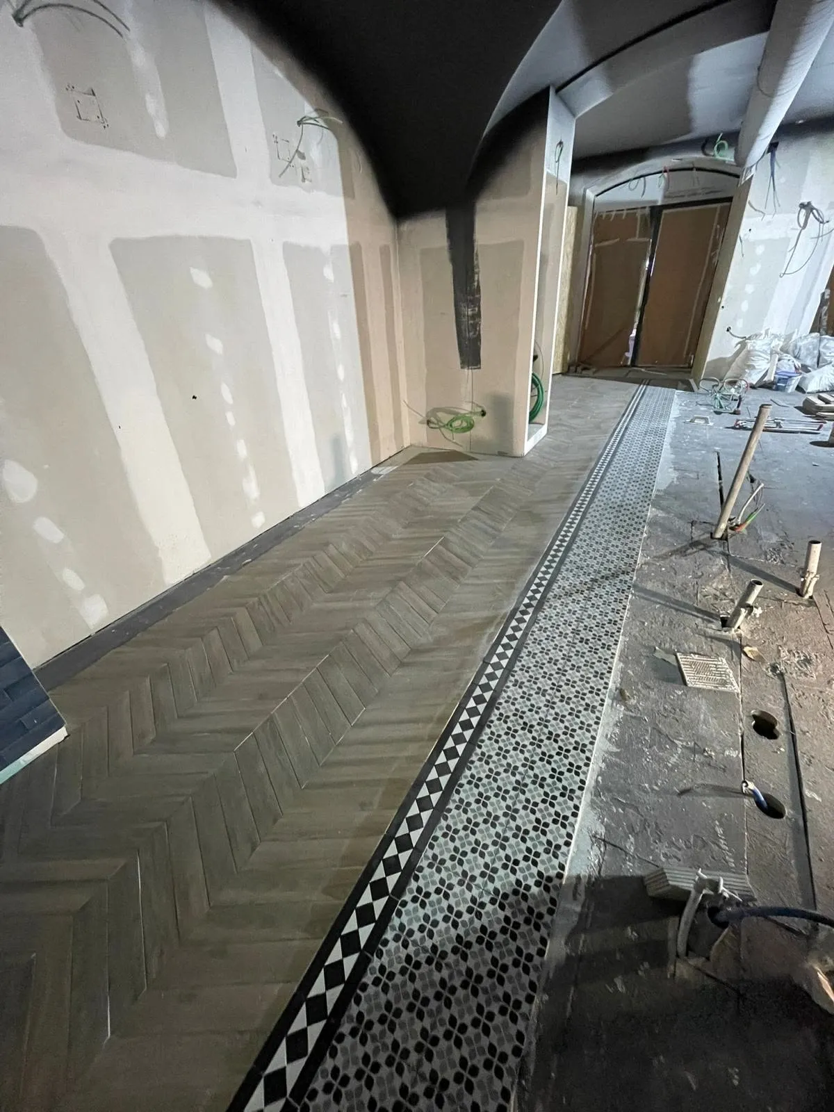Pavimento em execução: mosaico hidráulico e faixa decorativa a fazer a transição para a espinha de peixe
