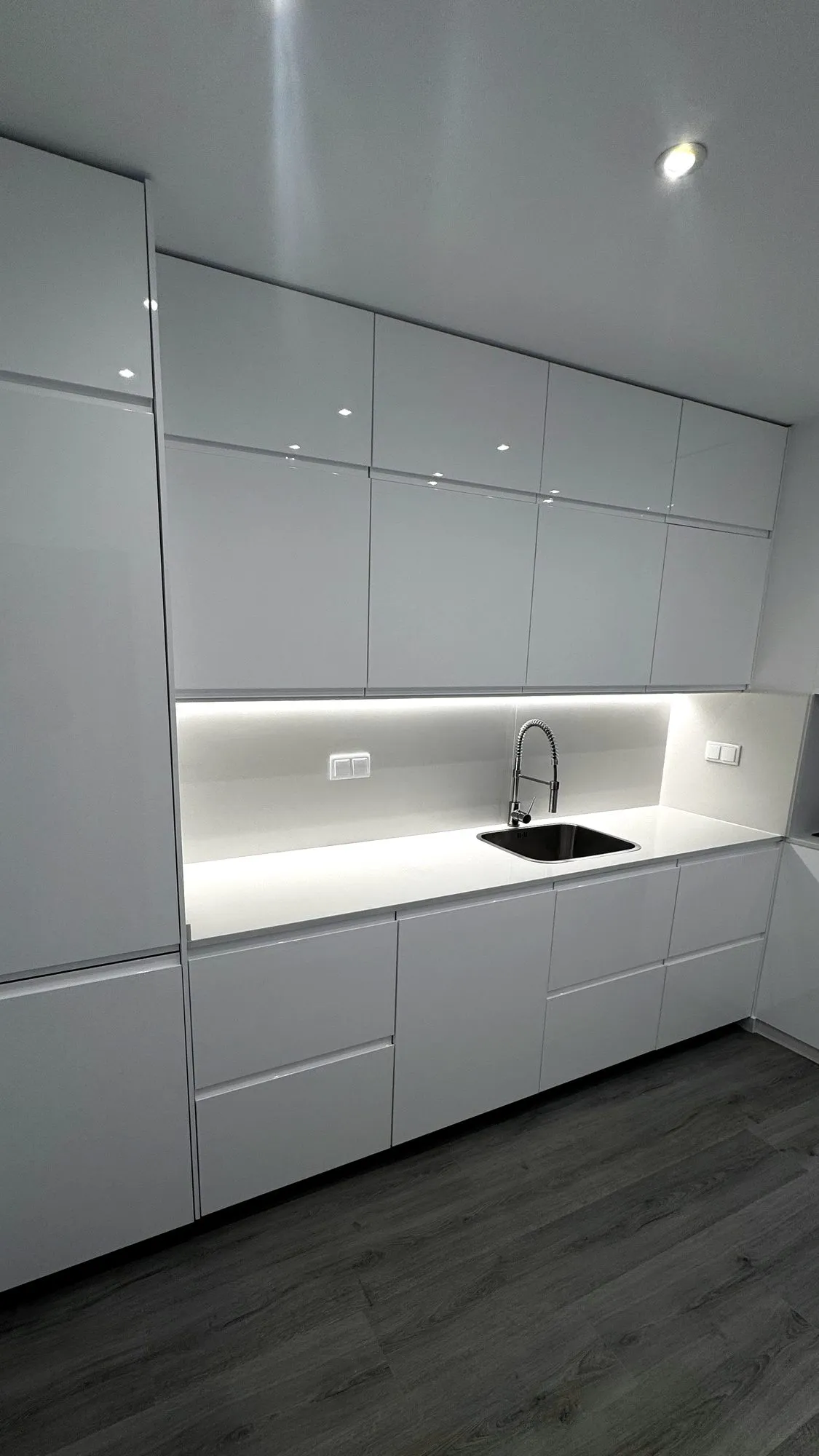 Cozinha lacada branca, feita por nós, com iluminação sob os armários e bancada em branco