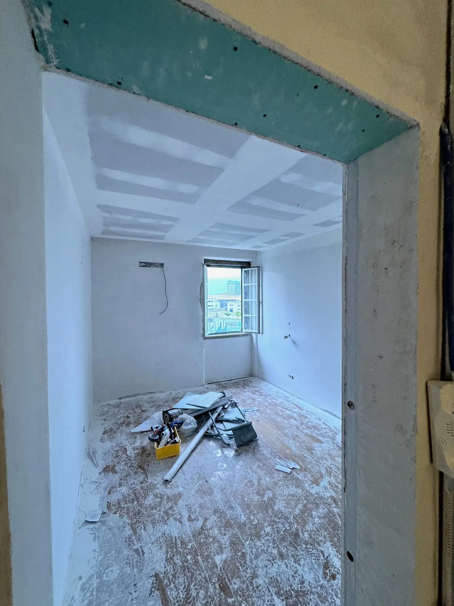 Estrutura em gesso cartonado hidrófugo a fechar o vão de uma casa de banho, ainda em obra