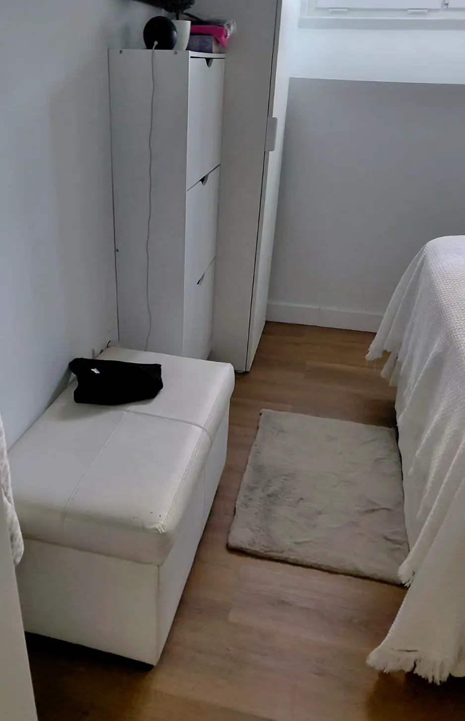 Zona de arrumação do quarto, com armários brancos de piso a teto