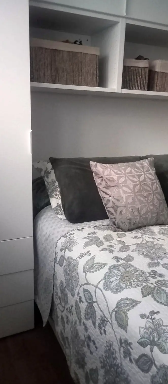 Quarto com armários e prateleiras embutidas por cima da cama