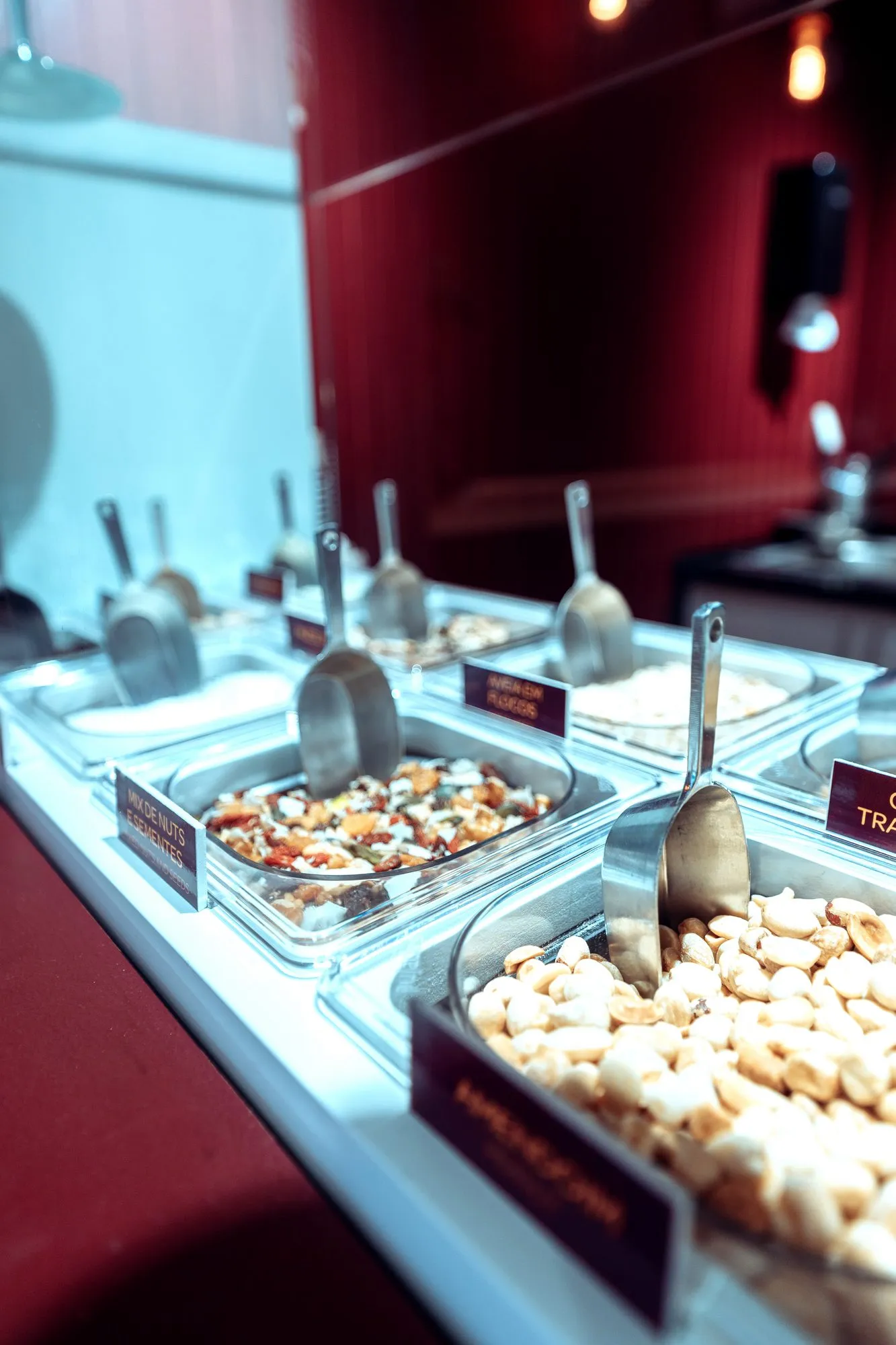 Vitrina refrigerada com os toppings, ao longo do balcão